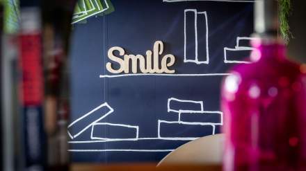 Décoration murale de l’Hôtel Ibis Budget Pontault-Combault avec le mot “Smile” en relief sur fond illustré de motifs de livres.