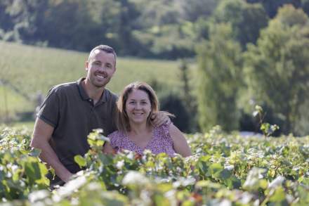 Deux personnes observant des vignes verdoyantes sous un ciel clair, cadre naturel et authentique – Fayet Hospitality