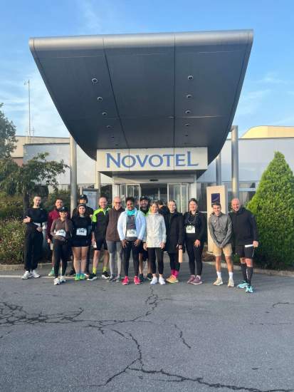 Groupe de participants en tenue sportive devant l’entrée du Novotel, Fayet Hospitality.
