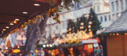 Décorations de Noël avec guirlandes et lumières sur un marché festif en extérieur, ambiance chaleureuse et illuminée – Fayet Hospitality