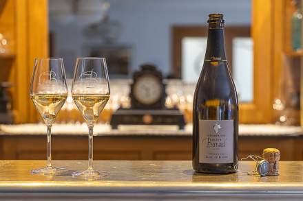 Bouteille de champagne avec deux verres servis sur un comptoir élégant, ambiance raffinée - Fayet Hospitality