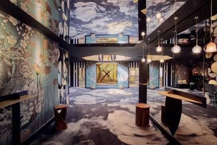 Hall artistique et contemporain du Novotel Collégien Marne-la-Vallée, décoré de fresques colorées, jeux de miroirs, lumières suspendues et mobilier design.