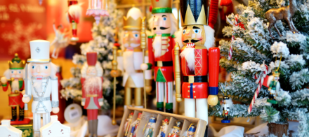 Collection de figurines casse-noisette colorées exposées avec sapins enneigés et décorations de Noël – Fayet Hospitality
