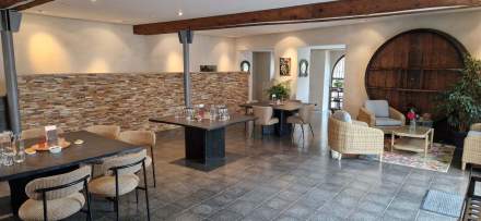 Salle élégante avec murs en pierre, poutres apparentes et mobilier contemporain – Fayet Hospitality